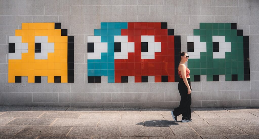 Woman walks past pac-man ghost mural on colorful mural