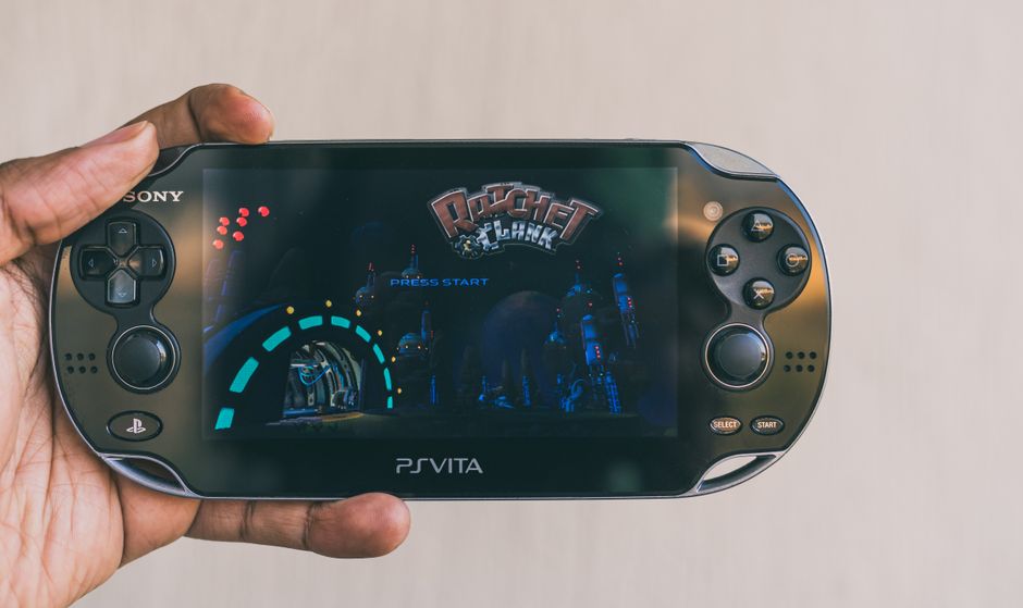 Close-up of a hand holding a PlayStation Vita with Ratchet & Clank displayed on screen. Captured in Johannesburg.