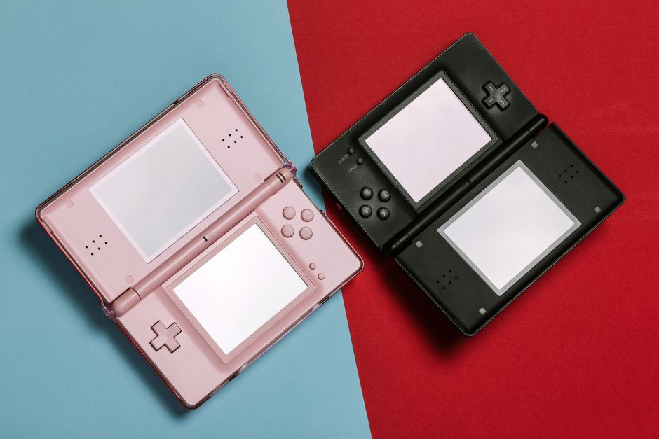 Pink and black Nintendo DS consoles displayed on contrasting red and blue backgrounds.